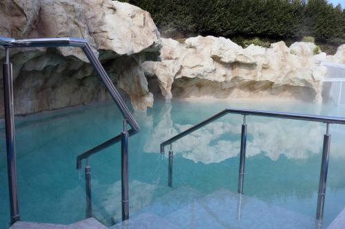 une piscine d'eau bleue avec des escaliers dans une grotte dans l'établissement Virginia Resort & Spa - Adults Only, à Avellino