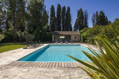 une piscine avec des chaises et une maison dans l'établissement MAS SAINT GEORGES DE L'ORATOIRE, à Châteaurenard