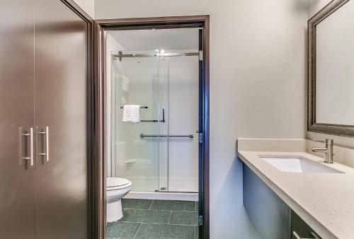 a bathroom with a shower and a toilet and a sink at Staybridge Suites Lubbock South by IHG in Lubbock