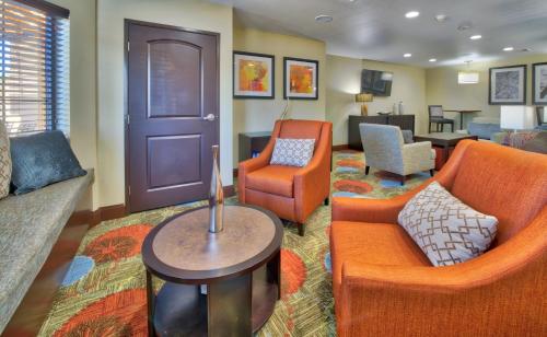 a living room with a couch and chairs and a table at Staybridge Suites Lubbock South by IHG in Lubbock