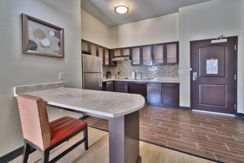 a large kitchen with a table and a refrigerator at Staybridge Suites Lubbock South by IHG in Lubbock