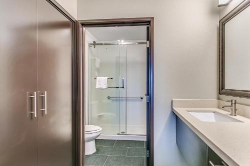 a bathroom with a shower and a toilet and a sink at Staybridge Suites Lubbock South by IHG in Lubbock