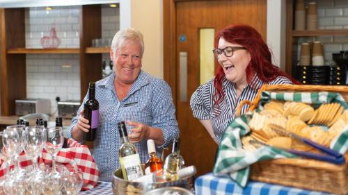 a man and woman sitting at a table with a bottle of wine at Staybridge Suites Liverpool by IHG in Liverpool
