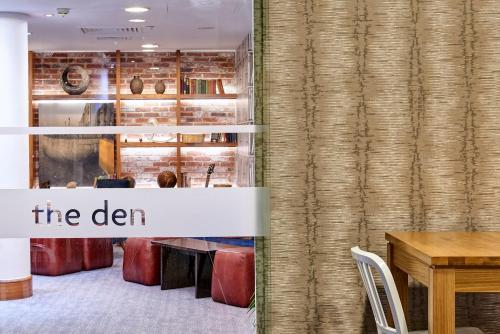 a dining room with a sign that reads the den at Staybridge Suites Liverpool by IHG in Liverpool