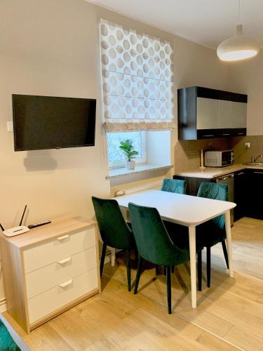 a kitchen and dining room with a table and chairs at Apartamenty Dobranocka in Krotoszyn