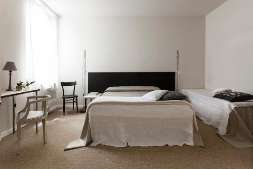 a bedroom with two beds and a table and a desk at Hotel Cervetta 5 in Modena