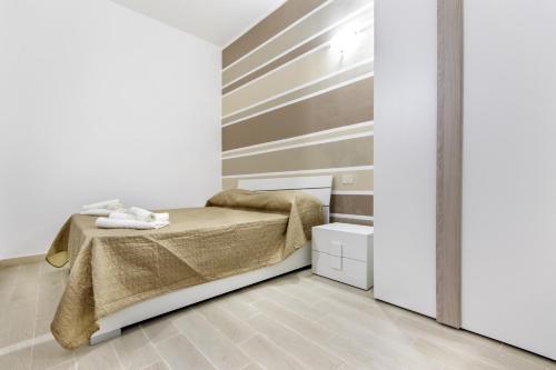 a bedroom with a bed and a wall at IN CENTRO ROOMS Vicino Cefalù SELF-CHEK-IN in Campofelice di Roccella