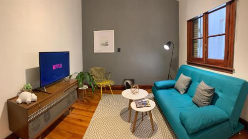 salon z niebieską kanapą i telewizorem w obiekcie Buenos Aires Downtown Experiencie #BAExp09 w BuenosAires
