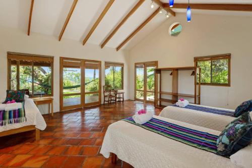 a bedroom with two beds in a room with windows at Anamaya Resort in Montezuma