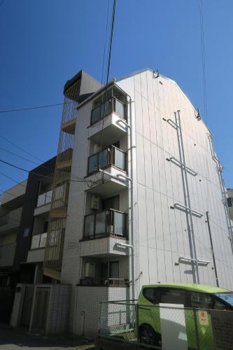 a building with a green van parked in front of it at SIMPLY WHiTE GUEST ROOM302 in Osaka