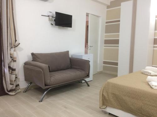 a living room with a chair and a bed at IN CENTRO ROOMS Vicino Cefalù SELF-CHEK-IN in Campofelice di Roccella
