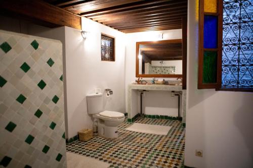 a bathroom with a toilet and a tiled floor at Dar Settash in Fès