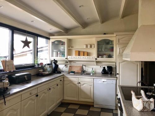 a kitchen with white cabinets and a white refrigerator at Forest Guesthouse in Bergentheim