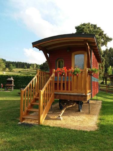 a small house with a porch and a deck at Camping Chez Prosper in Fournels