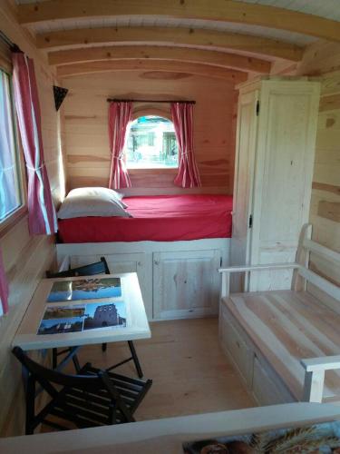 a small room with a bed and a table at Camping Chez Prosper in Fournels