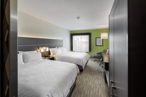 a hotel room with two beds and a desk at Holiday Inn Express & Suites - Saskatoon East - University by IHG in Saskatoon