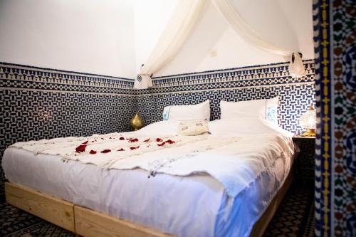 a bedroom with a bed with roses on it at Dar Settash in Fès