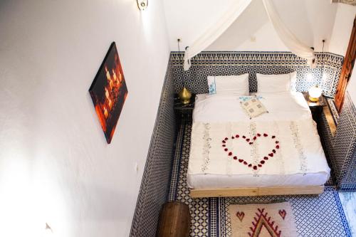 a bedroom with a bed with a heart drawn on it at Dar Settash in Fès