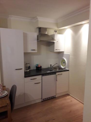 a kitchen with white cabinets and a sink at Haus-Claudia in Viehhofen