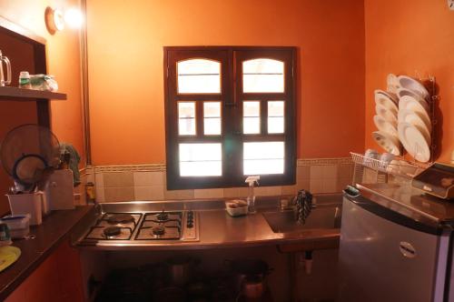 a kitchen with a stove and a sink and a window at Hospedaje Rural Misia Emilia in Medellín