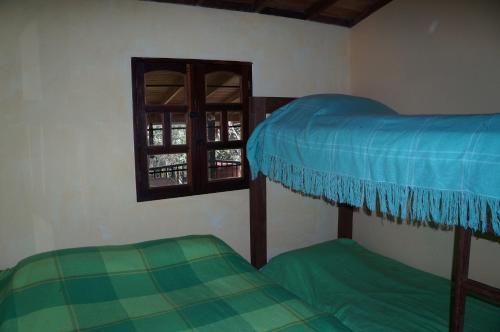 two bunk beds in a room with a window at Hospedaje Rural Misia Emilia in Medellín