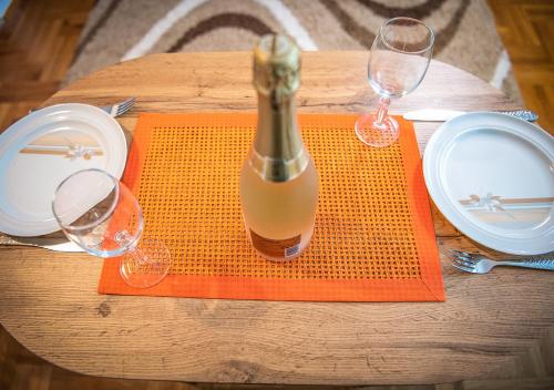 Una botella de vino sobre una mesa con dos copas. en Mina Penthouse, en Novi Sad