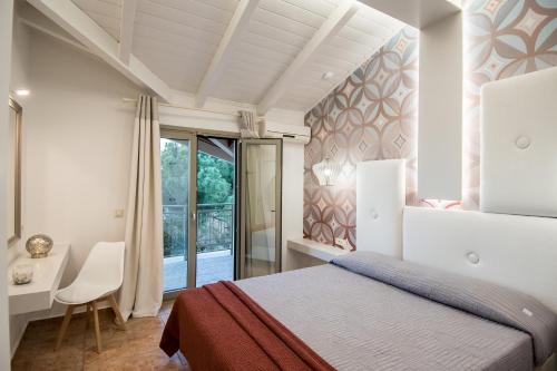 a bedroom with a bed and a desk and a window at Paradise Vezal in Laganas