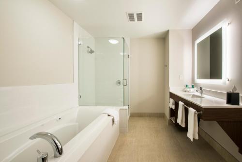 a bathroom with a tub and a sink and a shower at Holiday Inn Express & Suites Victoria-Colwood, an IHG Hotel in Victoria