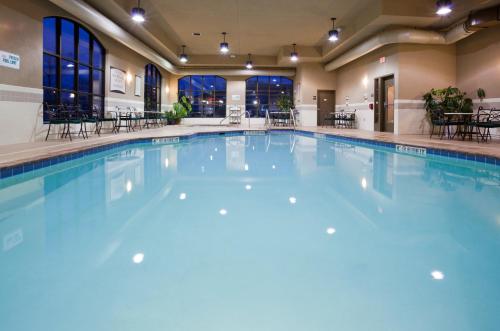 a large swimming pool with blue water in a building at Staybridge Suites Milwaukee Airport South by IHG in Franklin