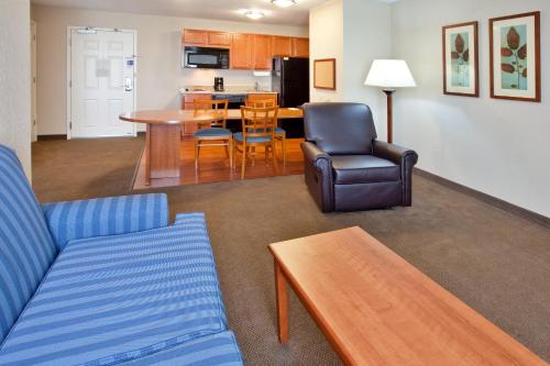 a living room with a couch and a table and chairs at Candlewood Suites Elgin – Northwest Chicago by IHG in Elgin