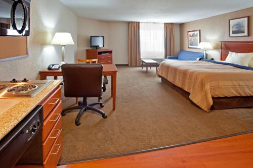 Habitación de hotel con cama y escritorio en Candlewood Suites Elgin – Northwest Chicago, an IHG Hotel, en Elgin