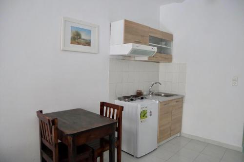 a small kitchen with a white refrigerator and a table at Camelia Studios in Yenion