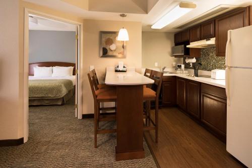 a room with a kitchen and a bedroom with a bed at Staybridge Suites Monterrey San Pedro by IHG in Monterrey
