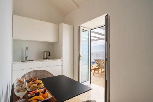 a kitchen with a table with a bowl of fruit at Escarpa - The Madeira Hideaway in Ponta do Sol