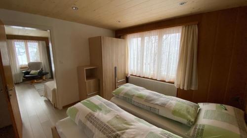 1 dormitorio con 2 camas y ventana en Chalet Acheregg, en Wengen