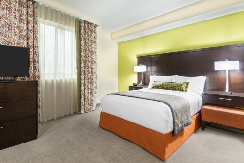マイアミにあるStaybridge Suites - Miami International Airport by IHGのベッドルーム(大型ベッド1台、薄型テレビ付)