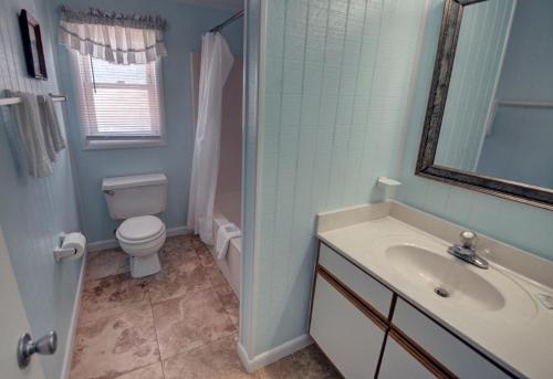 a bathroom with a sink and a toilet and a mirror at Outer Banks Motel in Buxton