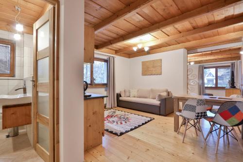 une cuisine et un salon avec une table et des chaises dans l'établissement Willa na Równi, à Zakopane