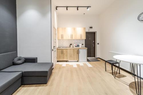 a living room with a couch and a kitchen at Modern Apartment in the Old City in Lviv