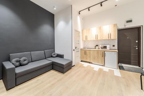 a living room with a couch and a kitchen at Modern Apartment in the Old City in Lviv