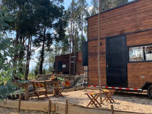 a tiny house in the woods with a table and chairs at El Bosque de Paipa in Paipa