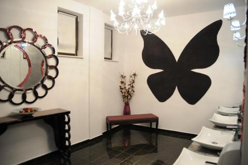 a bathroom with a mirror and a butterfly on the wall at Papillon in Piteşti