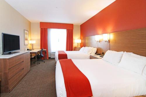 a hotel room with two beds and a flat screen tv at Holiday Inn Express and Suites Calgary University by IHG in Calgary