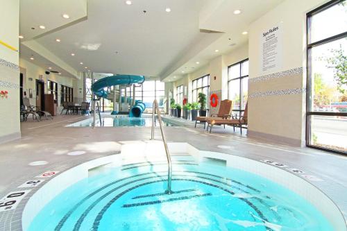 a large swimming pool in a building with a slide at Holiday Inn Express and Suites Calgary University by IHG in Calgary