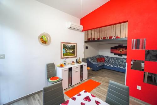 a kitchen and living room with a red wall at Villa Bouganville in Bibione