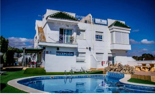 um grande edifício branco com uma piscina em frente em HOTEL Palomares Beach em Palomares