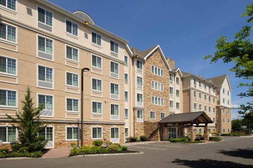 a large apartment building with a parking lot at Staybridge Suites North Brunswick by IHG in North Brunswick
