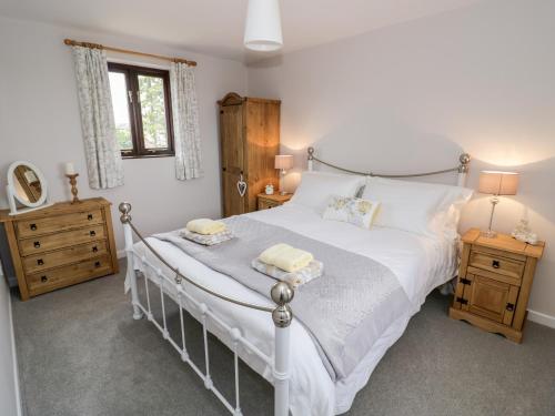 a bedroom with a white bed with two towels on it at Kite Cottage in Brackley