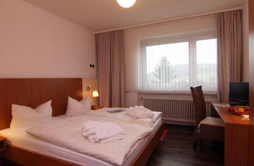 a hotel room with a bed with towels on it at Hotel Lahnblick in Bad Laasphe