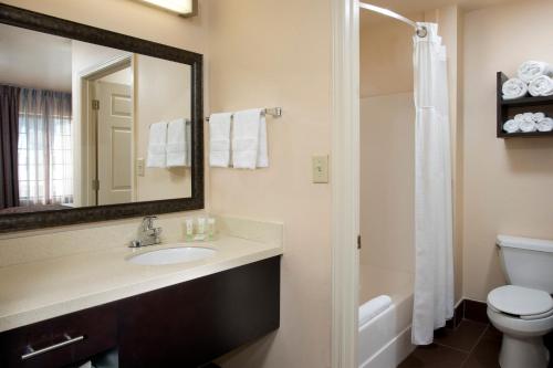 ein Badezimmer mit einem Waschbecken, einem WC und einem Spiegel in der Unterkunft Staybridge Suites Myrtle Beach-Fantasy Harbour, an IHG Hotel in Myrtle Beach